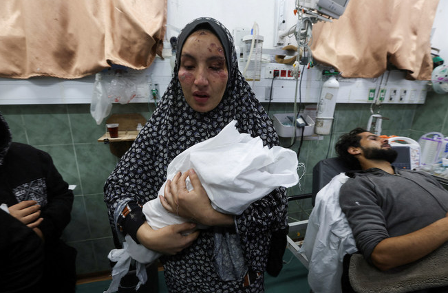 Palestinian woman holding kid in Hospital