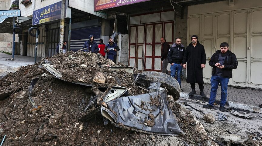 mangled wreckage of a car hit by an Israeli air strike targeting a top militant
